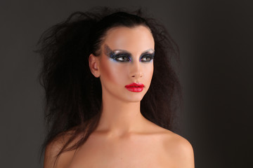 Fototapeta premium Naga kobieta z makijażem i dzikimi włosami. Ścieśniać. Szare tło