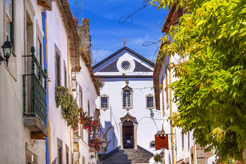 Fototapeta na wymiar Sao Pedro Church Narrow White Street Obidos Portugal