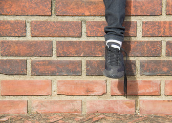 Woman foot brick wall background