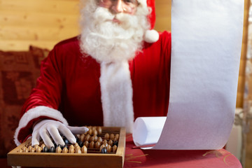 Santa Claus holding his gift list and counting