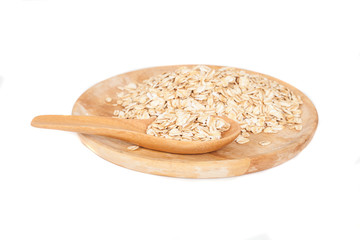 dish and wood spoon with oats flakes pile