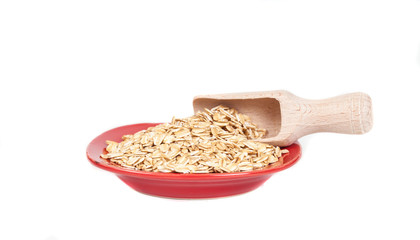 red dish  with oats flakes pile on white background.