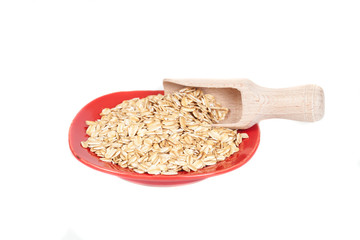 red dish  with oats flakes pile on white background.