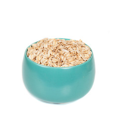 oats flakes pile in bowl on wood background.