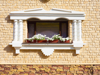 White flowers hangs on the window of a home in an ancient buildi