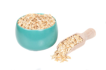 oats flakes pile in bowl on wood background.