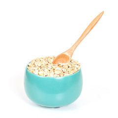 oats flakes pile in bowl on wood background.