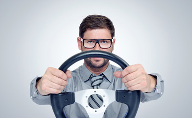 Funny bearded man in glasses with a steering wheel 