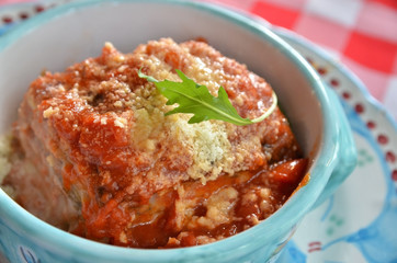 Portion of delicious  lasagna baked on ceramic bowl. Typical Italian plate.