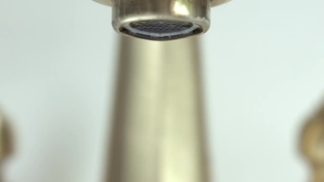 Dramatic Footage of Leaking Bathroom Faucet Over Gray Background.