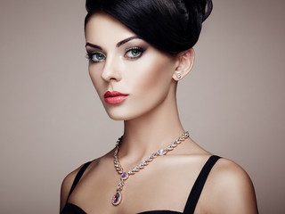 Fashion portrait of young beautiful woman with jewelry and elegant hairstyle. Brunette girl. Perfect make-up.  Beauty style woman with diamond accessories