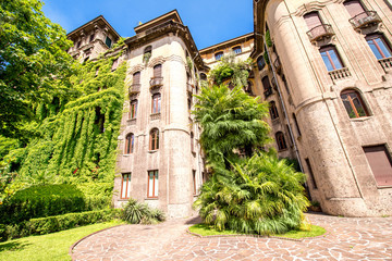 Old beautiful residantial building with tree and ivy in Milan city