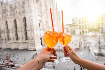  Clinking glasses of spritz aperol drink on the main square with Duomo cathedral on the background in Milan city © rh2010