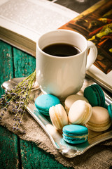fresh macaroons and tea cup on wooden table .Vintage filter