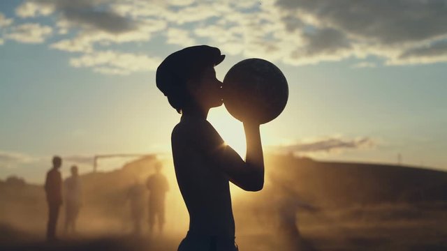 Child in hat kissing ball outside