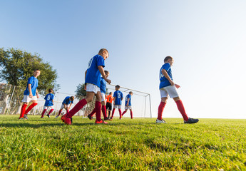 Boys playing football soccer game on sports field