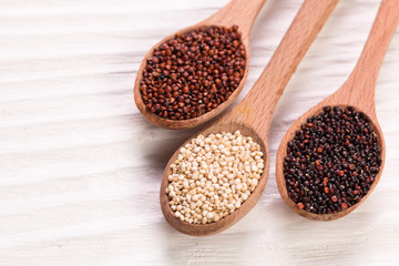 Red, black and white quinoa seeds on a wooden background,healthy food.