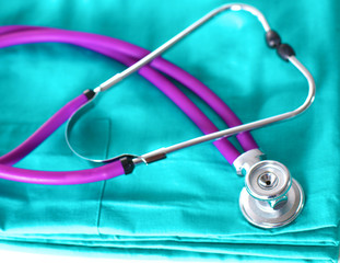 stethoscope shaping heart and clipboard on medical uniform, closeup