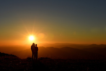 People relaxing and enjoying sunset in the mountains