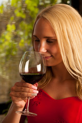 Beautiful woman drinks red wine outdoor on a hot summer afternoo