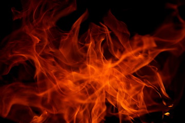 Fototapeta premium Closeup of a large fire. Wooden planks to the fire. The fire is lit in the night.