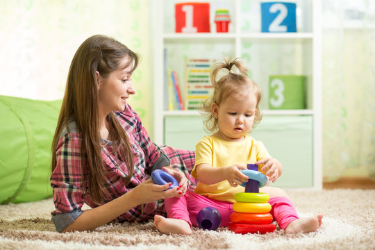 Mother and kid with toys in playroom