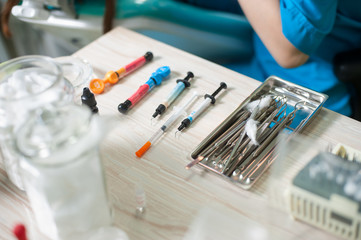 Consumables dental materials and dental instruments on the table near doctor in the dentist's...