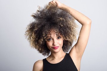 Naklejka premium Young black woman with afro hairstyle smiling