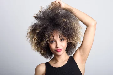 Fotobehang Young black woman with afro hairstyle smiling © javiindy
