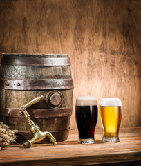 Glasses of  beer and ale barrel on the wooden table. Craft brewe