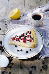 Sunny Photo of morning breakfast in a rustic style. Cheesecake with raspberries and blueberries on wooden table. Selective focus picture