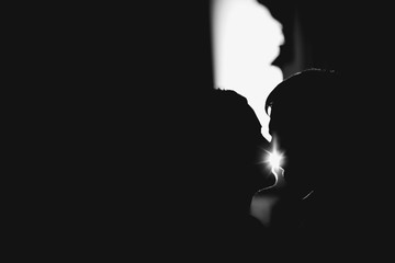 young man kissing his lady in dark