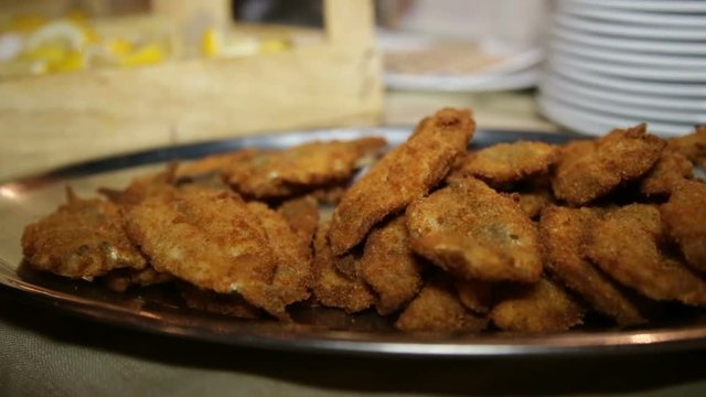 Pesce impanato e fritto disposto su un piatto metallico ad un Buffet Nuziale.
