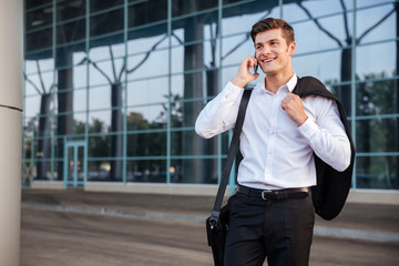 Businessman in white shirt talking on cell phone outdoors