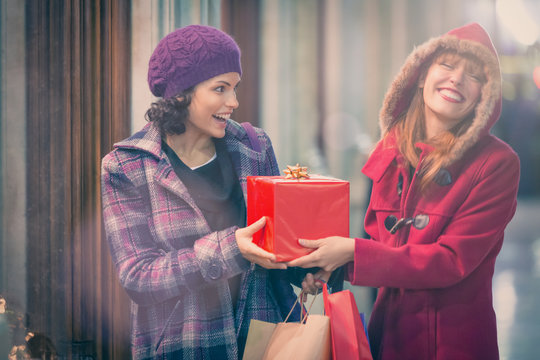 two young woman shop during christmas time in a cityscape