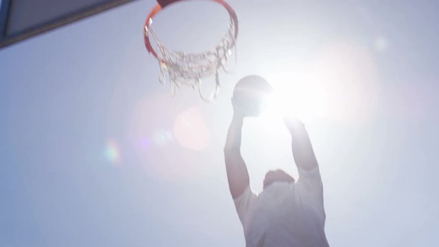 African american basketball player slam dunking, in slow motion