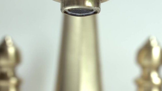 Macro Dramatic Footage of Leaking Bathroom Faucet Over Gray Background.