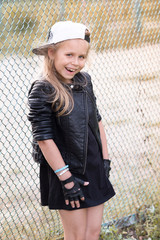 little girl in a fate style in a park on a ground
