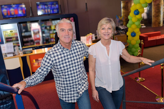 Senior Couple Walking Up Stairs In Cinema