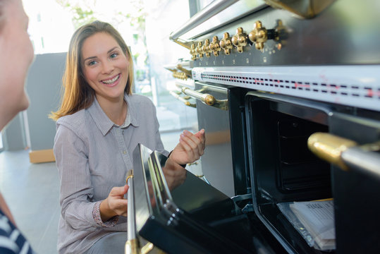 Woman showing oven to customer