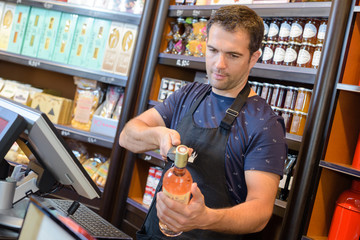 Man scanning bottle of wine at checkout