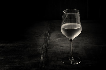 Dry cold white wine, vintage dark wood background, black and whi