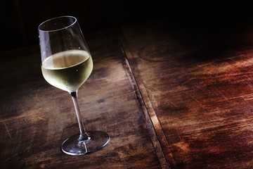 Dry cold white wine, vintage dark wood background, selective foc