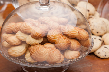 lot of cookies in a vase of glass on the background crumbly biscuits