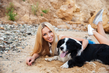Happy woman relaxing with dog on the beach