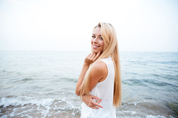 Fototapeta na wymiar Smiling woman standing on the seaside