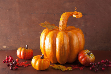 decorative golden papier-mache pumpkin and autumn leaves for hal