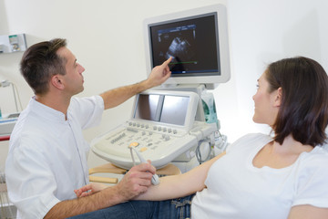 Obraz premium Doctor performing ultrasound explaining findings to patient