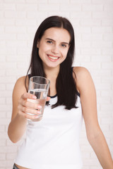 Girl drinking water at home. Glass of water in morning before breakfast.