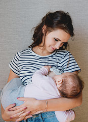 Beautiful young mom breastfeeding her 5 months baby. Mather nursing baby. Family at home. © Romanova Anna